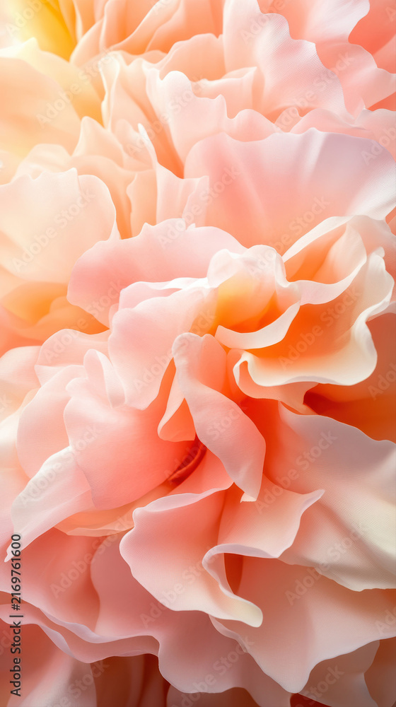 Fototapeta premium A close-up of coral peony petals, exhibiting a velvety texture and ruffled edges. The interplay of sunlight and shadows accentuates the peach to pale pink color gradients.