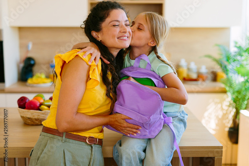 Cuadro en lienzo Daughter getting ready for school while mother helps with backpack