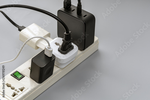 Canvas Print A close-up view of a white power strip overloaded with multiple black and white