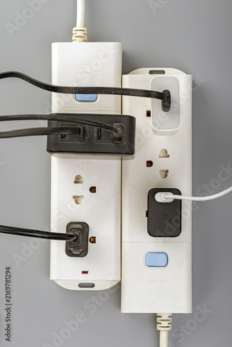 Canvastavla Close-up view of two white power strips mounted on a gray wall, connected togeth