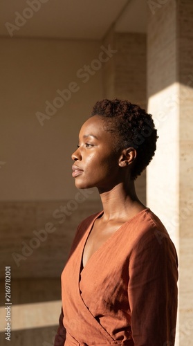 Profile portrait of a beautiful African American woman with short hair illuminated by warm natural sunlight
