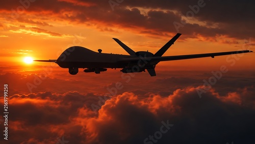 Military drone flying in dramatic sunset sky with vibrant clouds and golden sun rays illuminating.