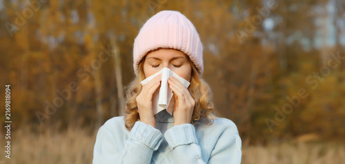 Sick woman sneezing blow nose using tissue, unhealthy suffering girl feels unwell outdoors