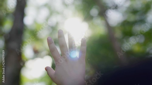  The young woman is pulling her hand toward the sunlight.