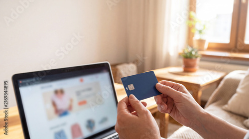 Hands Holding Blue Credit Card in Front of Laptop for Online Shopping and Ecommerce Payment