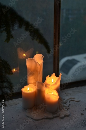 Принти на полотні Group of Burning White Candles Melting on Windowsill