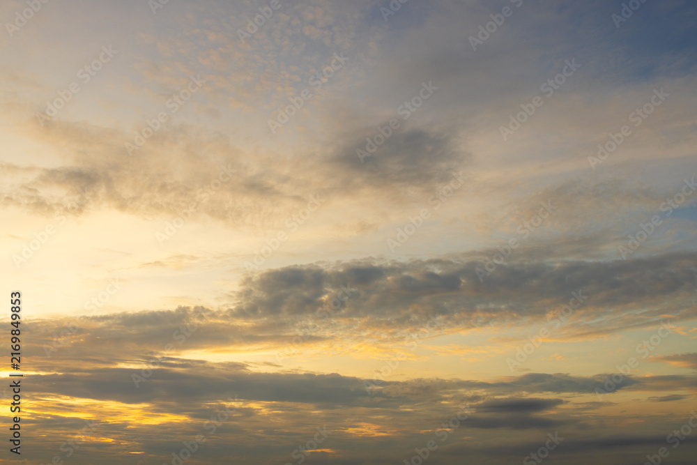 Obraz premium Beautiful Golden Hour Sunset Sky with Soft Clouds,A serene and peaceful view of the evening sky during sunset, featuring warm golden light illuminating soft clouds and a gentle gradient of blue.