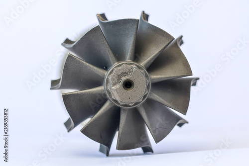Fotografie Macro front view of automotive turbocharger steel turbine wheel rotor blades on white background