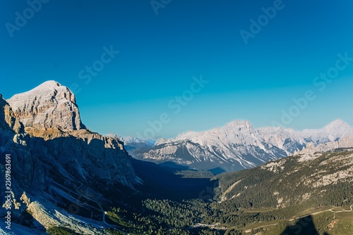 A pointed Dolomite summit towers over a green valley beneath a deep blue sky. Iconic alpine peak and dramatic scenery for hiking, adventure travel and tourism marketing