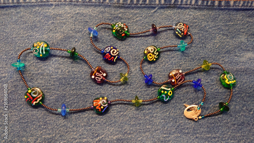 Принти на полотні Boho dichroic glass bead necklace on indigo jeans background