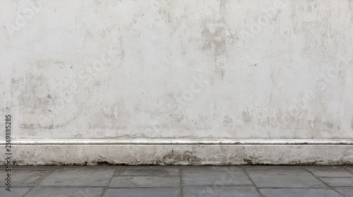 An old weathered concrete wall with a rustic texture and stone floor surface. Ideal for modern product display backgrounds and interior design.