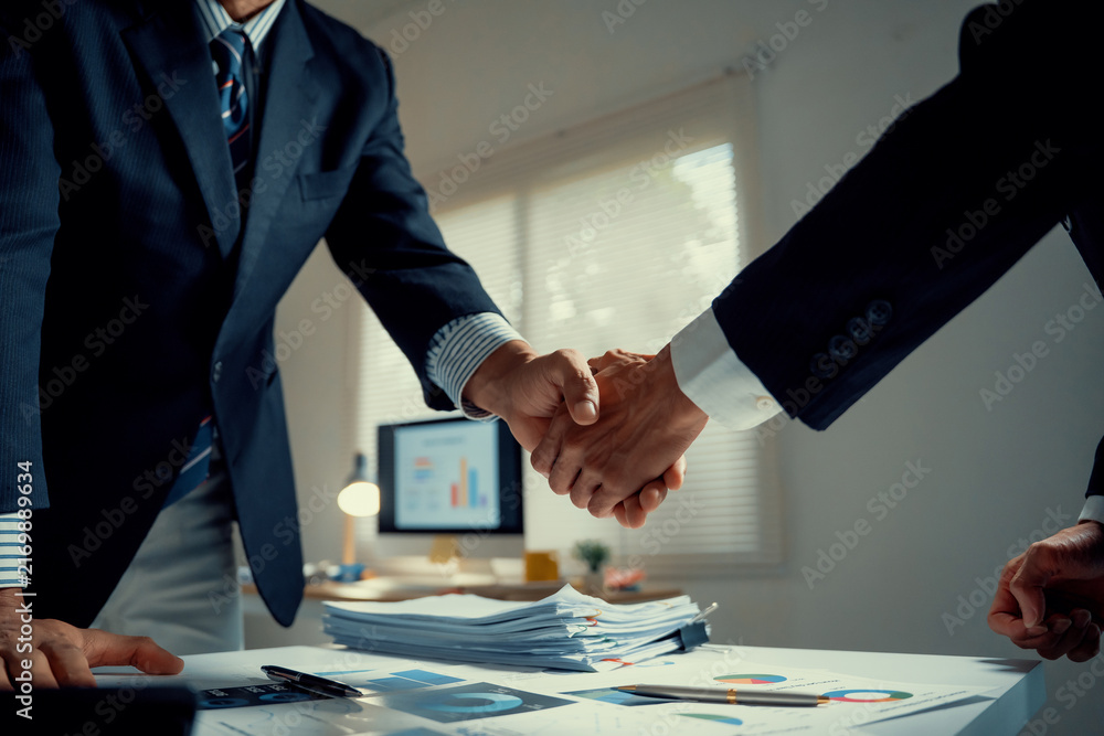 Naklejka premium Businessmen shaking hands making agreement in office
