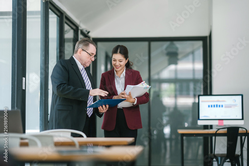 Business professionals collaborating on paperwork in modern office