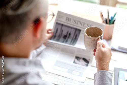 Obraz na plátně Man reading business newspaper calmly