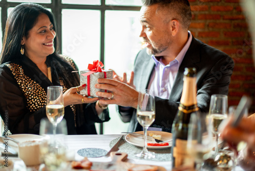 Konstfotografi Two people exchanging a gift at a festive dining table setting.