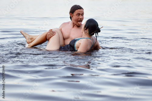 Fotografie A cheerful interaction between caouple in a lake, sharing laughs and joy in summer