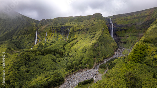 Fotografie Corvo, Azores, Portugal Dense green hillsides frame multiple waterfalls cascading down rocky cliffs