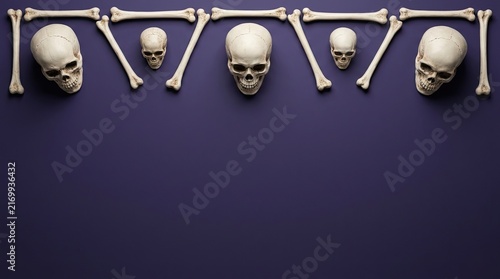 Top border made of human skulls and bones on a dark purple background for a halloween celebration