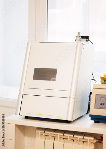 Bild auf Leinwand Wet dental milling machine used for CAD CAM production of crowns, bridges, inlays and onlays from glass ceramic and composite resin in a modern dental laboratory