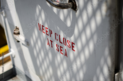 Obraz na plátne Weather-tight door providing access to the accommodation area on board an offshore support vessel, marked “KEEP CLOSED AT SEA