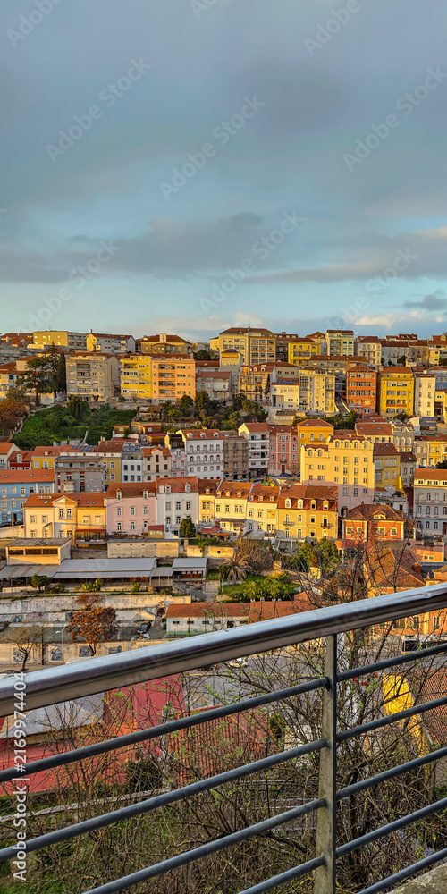 Fototapeta premium View from balcony overlooking the historic cityscape and traditional rooftops of Coimbra, Portugal.