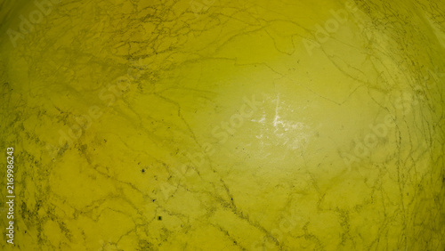 A close up overhead macro view highlights a thick layer of bright green textured algae blooming across the surface of a stagnant rural country pond in the summer.