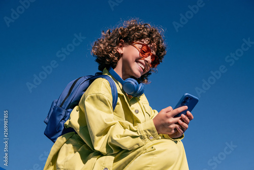 Young Student Using Smartphone Under Blue Sky