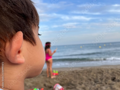Fotografie Close-up profile photograph of a young boy looking attentively out towards the sea