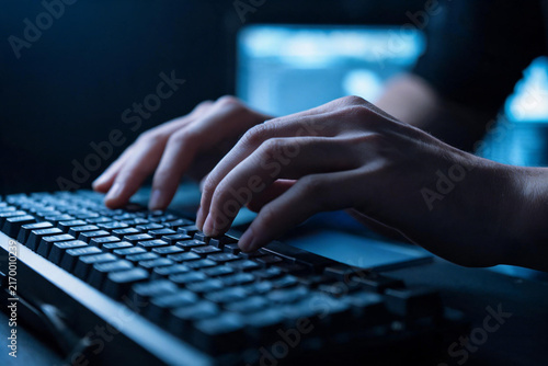 hands typing on a keyboard Close‑up of human hands typing on mechanical keyboard in dim dark office