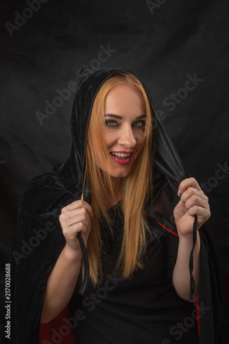 Obraz na płótnie Young woman with blonde hair and green eyes smiling playfully, holding the draws
