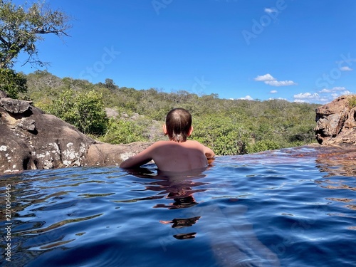 Boy relaxing in a crystal-clear natural pool at Las Pozas in the Chiquitania region of Bolivia.