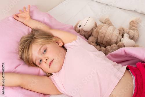 Obraz na płótnie Happy Young Girl Waking Up and Stretching in Bed
