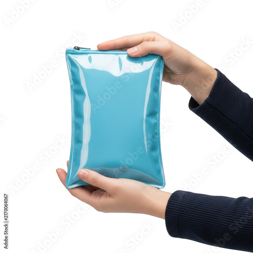Person holding blank blue cosmetic pouch isolated on transparent background for beauty product branding mockup