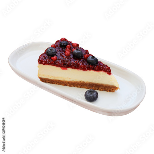 Fotografie Slice of creamy New York-style cheesecake on a white oblong plate, generously covered with a rich red berry compote and fresh blueberries