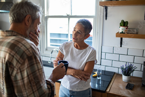 Mature couple having a serious talk in home kitchen