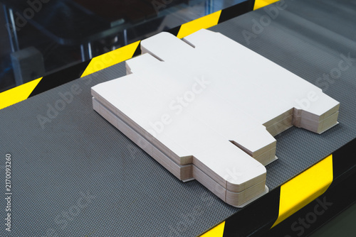 line of assembly of cardboard packaging in boxes and finished products. tech industrial technology background