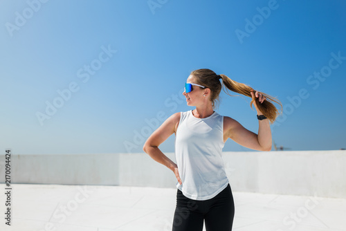 Canvastavla Bright sunshine shines on a fit woman with shades enjoying a perfect day outdoor