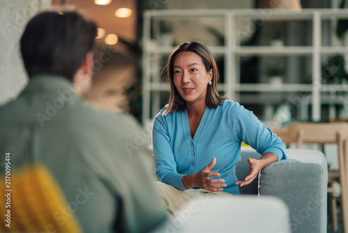 Принти на полотні Asian businesswoman communicating with male colleague, discussing project, colla