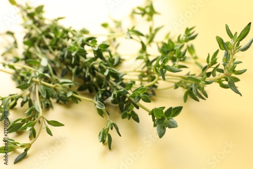 Fotografie Fresh thyme stems on yellow background, closeup