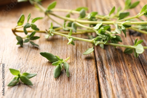Fotografie Fresh thyme stems on wooden table, closeup