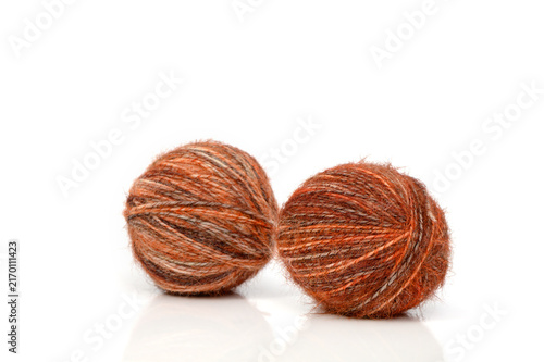 Canvas Print Soft tufts of vibrant orange yarn rest on a clean white surface, ready to bring