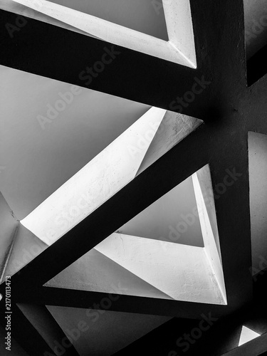 Fotografía A high contrast black and white fine art photograph showcasing minimalist geometric lines, triangles, and intersecting concrete structural shapes