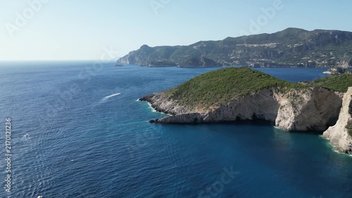 4K Aerial high‑angle 180‑degree panorama shot over Chomi Beach with turquoise water and white cliffs near Paleokastritsa, Corfu, Greece