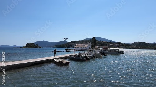 4K 240fps slow motion shot of a Ryanair plane flying low over the Holy Monastery of Panagia Vlacherna