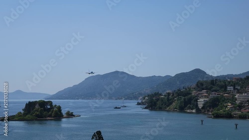 4K shot capturing a TUI passenger plane landing at Corfu Airport, Greece, over the iconic turquoise waters and planespotting area