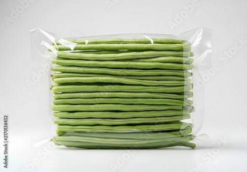 Fresh long beans vacuum-packed in clear plastic packaging on a white background.