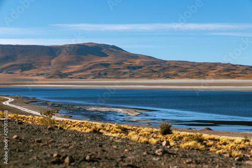 Foto Atacama desert salt flat with dark blue salar de tara lagoon reflecting a clear