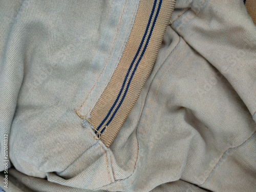 Canvastavla Denim fabric seam with parallel blue lines and folds.