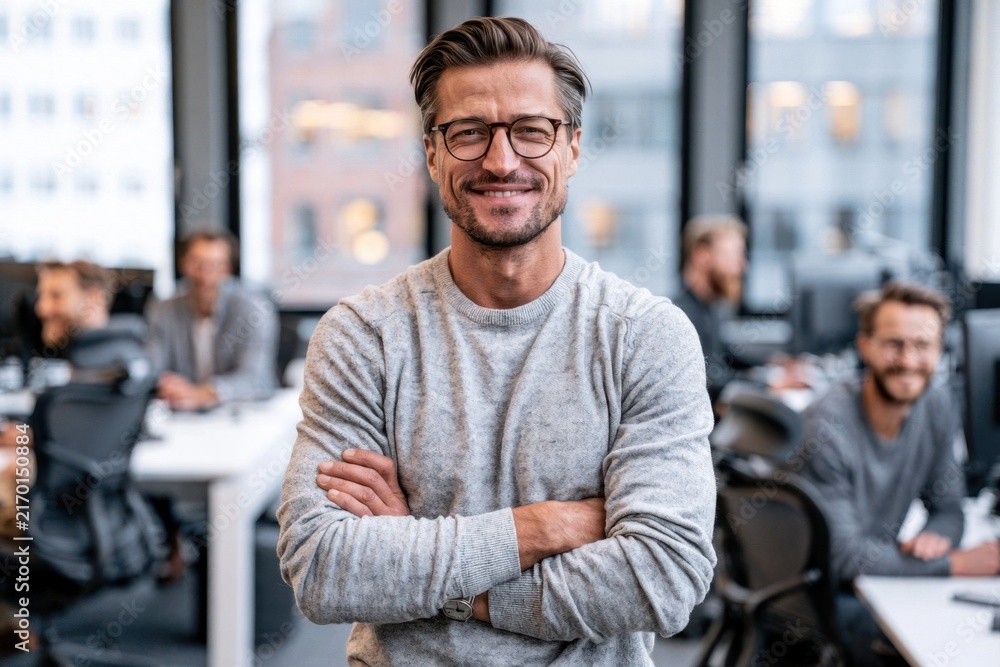 Fototapeta premium Confident man smiling in office workspace