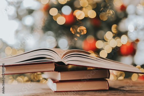 Christmas reading. Book Stack With Christmas Bokeh Background.festive literary background for bookstore advertising, library events, winter reading challenges and holiday storytelling.